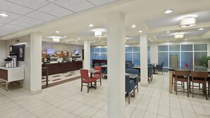 Un hall d’entrée spacieux avec plusieurs coins salon, un comptoir d’accueil et un espace dédié au café.