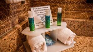 A bathroom setup with toiletries, a towel rack, and a sign listing amenities. - Holiday Inn Express Hotel & Suites Concord by IHG (Kannapolis)