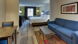 A hotel room with a bed, a blue sofa, a desk, and a chair. - Holiday Inn Express Hotel & Suites Dayton-Centerville by IHG (Dayton)