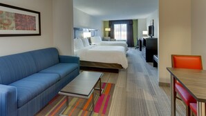 A hotel room with a blue sofa, a bed, a desk, and a TV. - Holiday Inn Express Hotel & Suites Dayton-Centerville by IHG (Dayton)