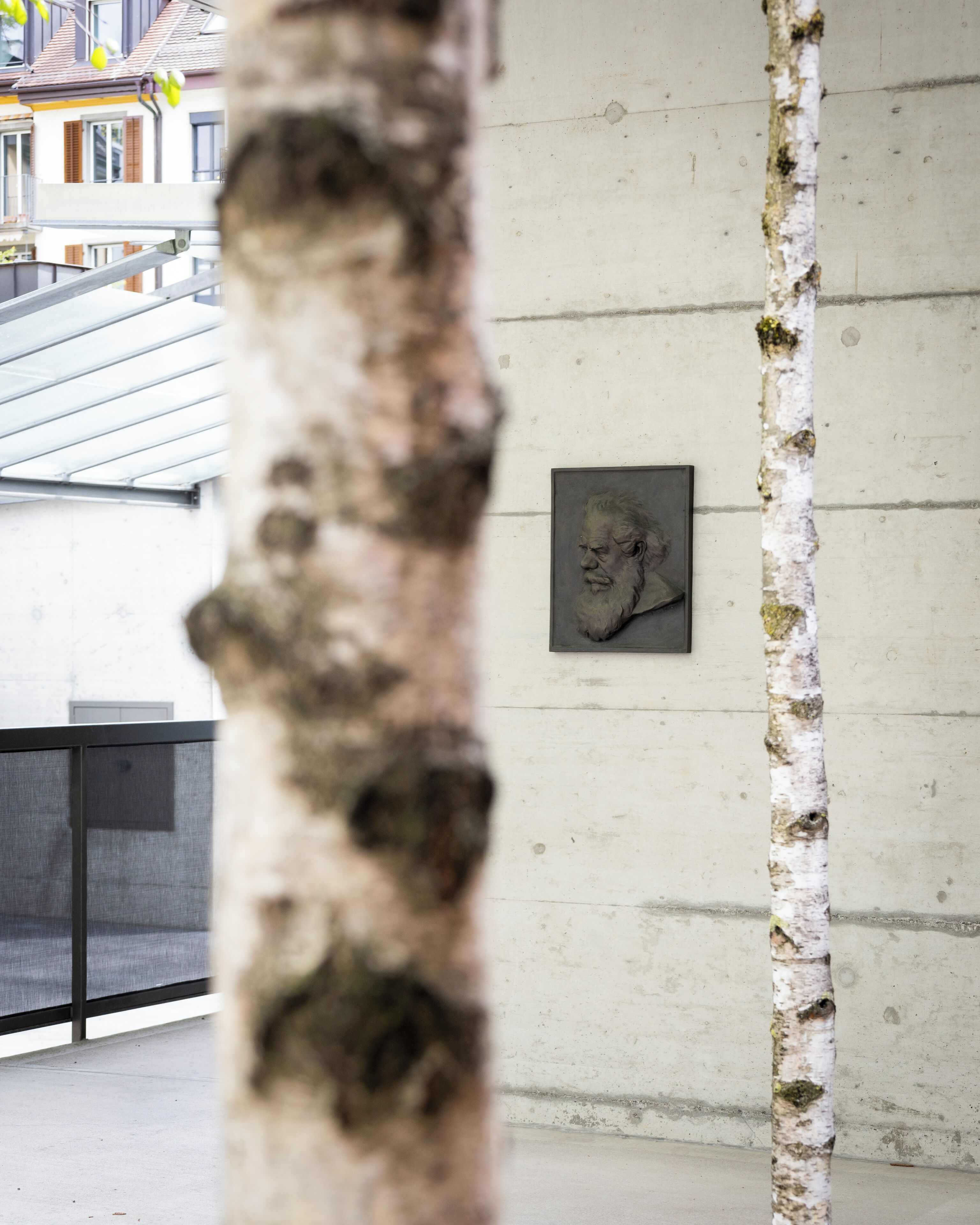 A concrete wall with a framed sculpture.