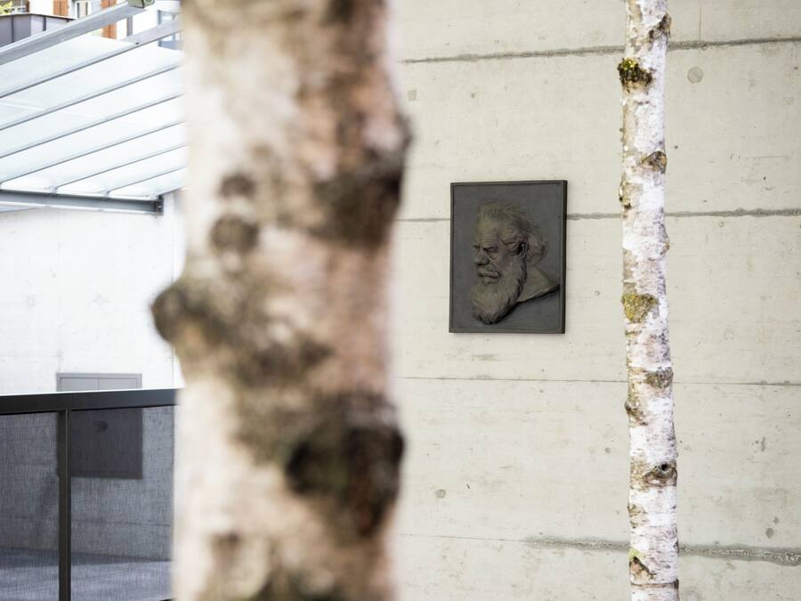 A concrete wall with a framed sculpture.