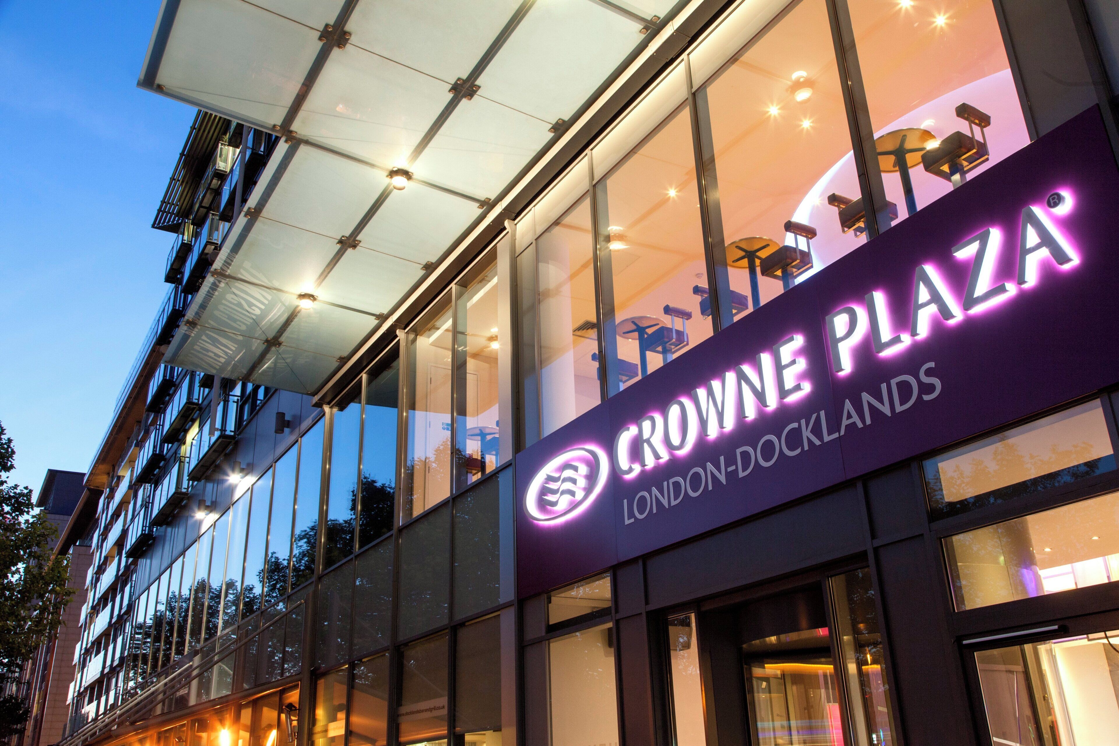 Un edificio con fachada de vidrio y un letrero que dice 'CROWNE PLAZA LONDON-DOCKLANDS'.