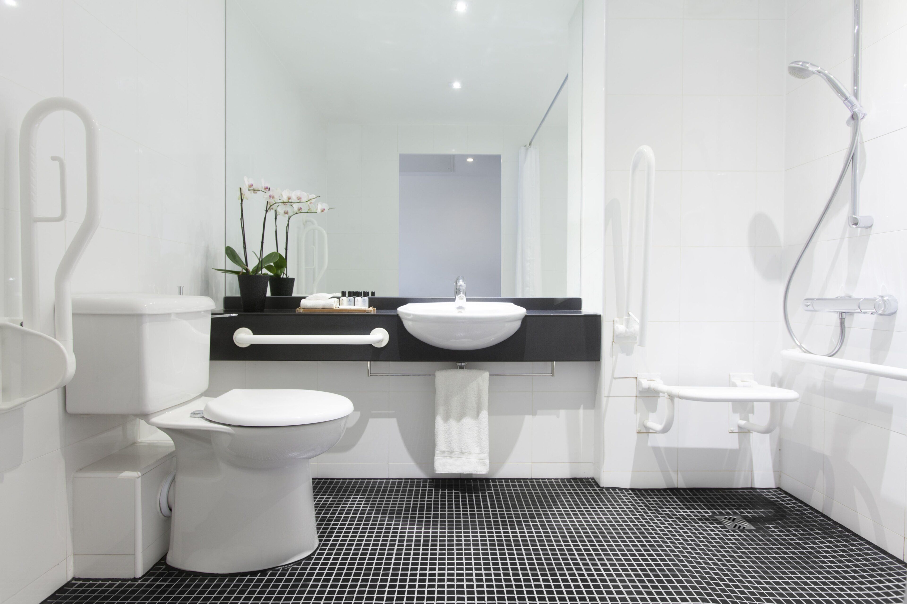 A modern bathroom with a toilet, sink, and shower.