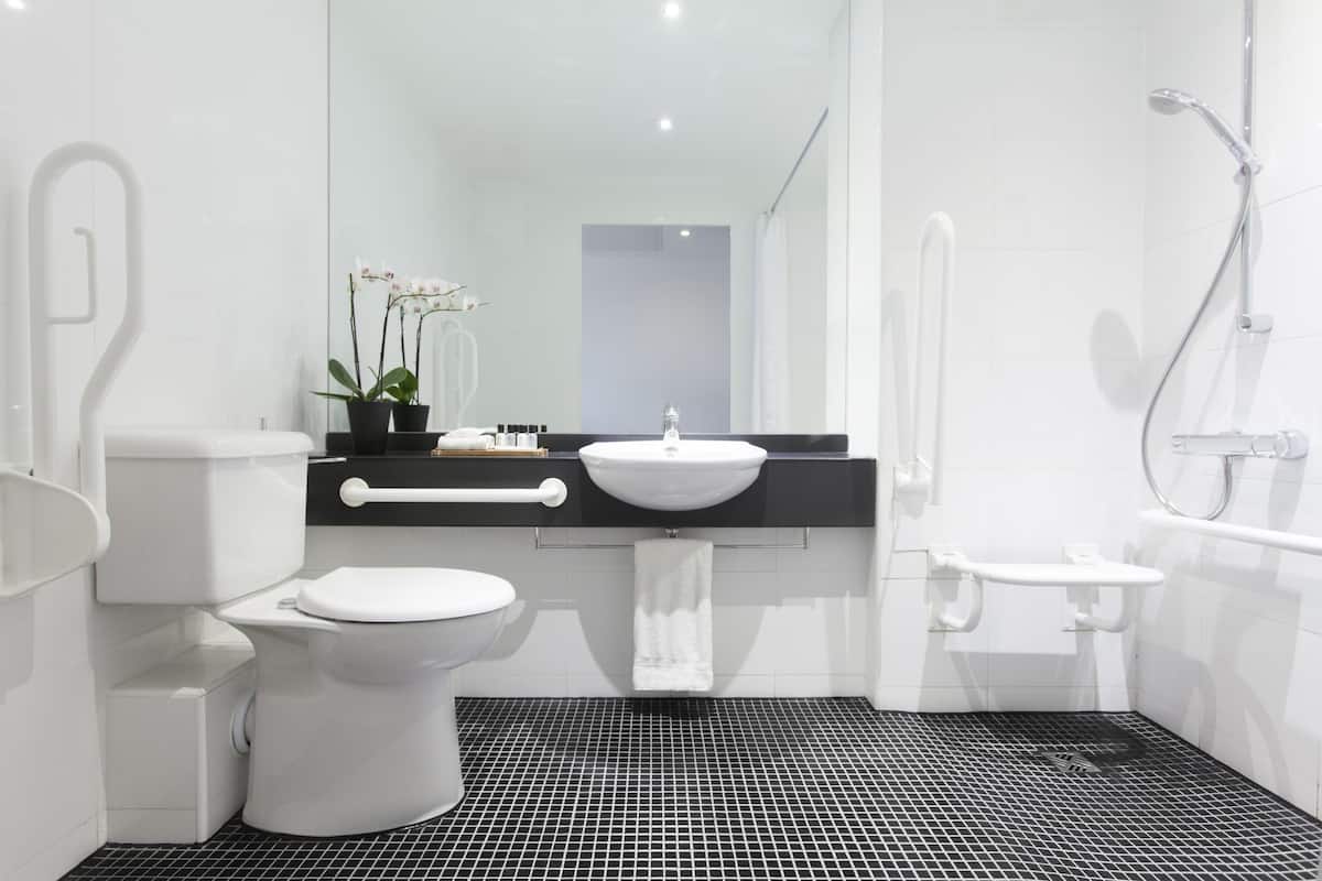 Een moderne badkamer met toilet, wastafel en douche.