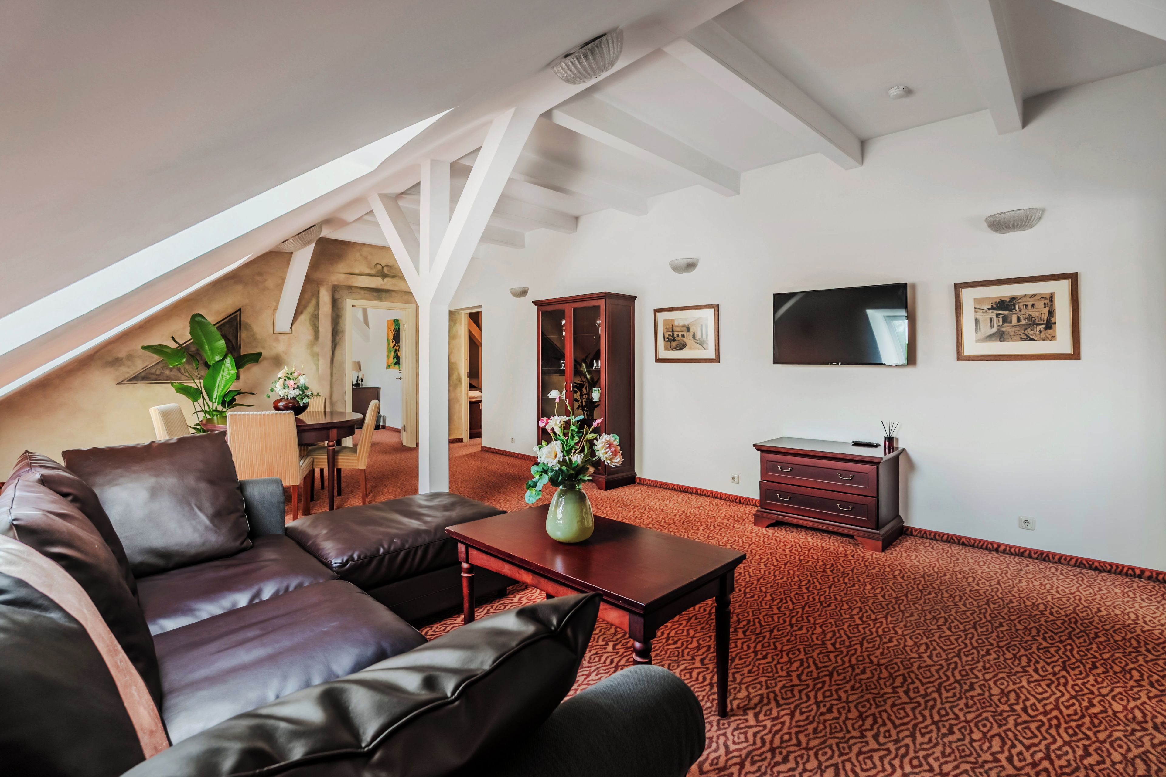 Un salón comedor espacioso con techos altos, chimenea, zona de estar y televisor.