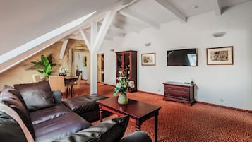 Un salón comedor espacioso con techos altos, chimenea, zona de estar y televisor.