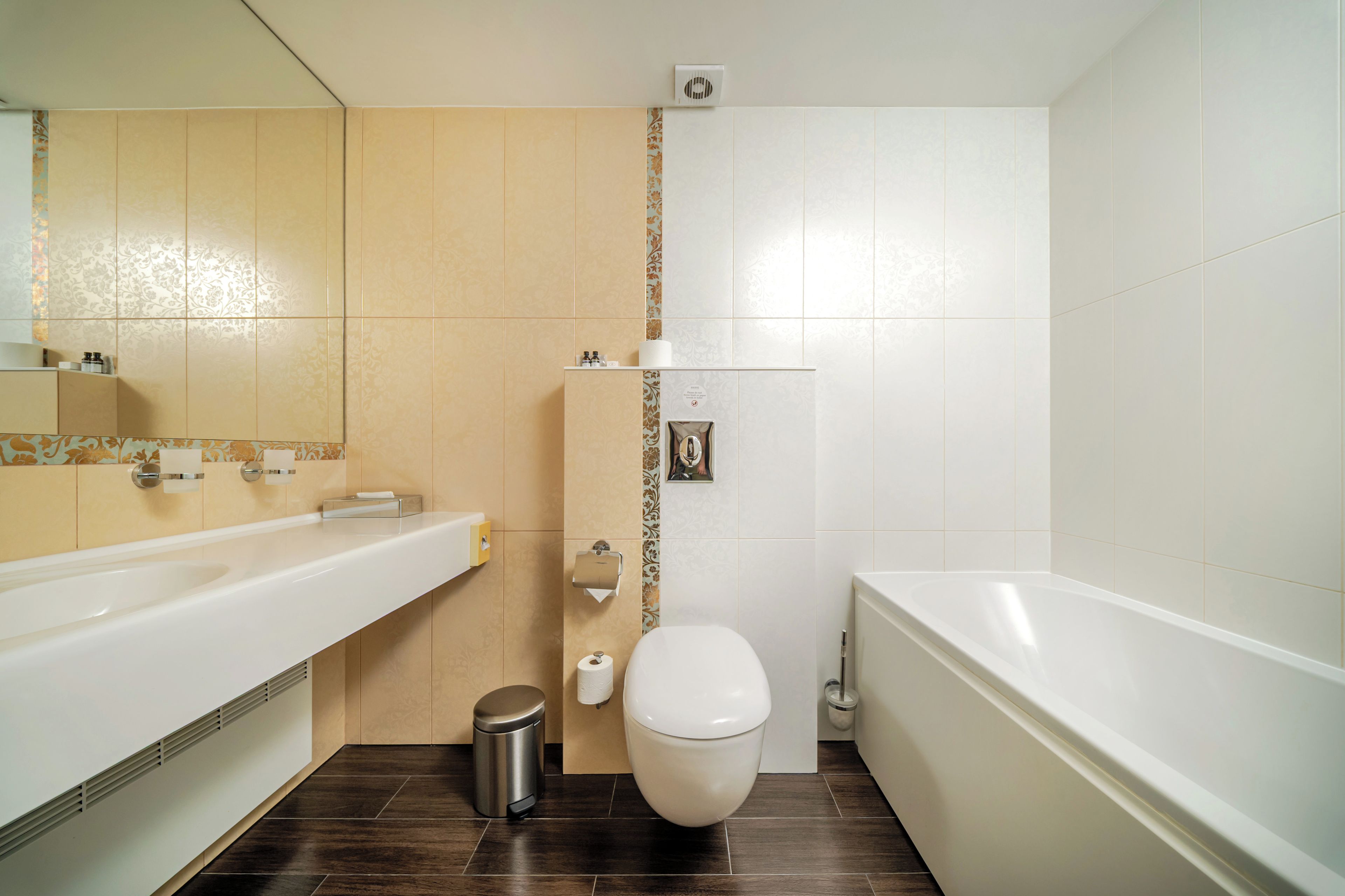 A modern bathroom with a bathtub, toilet, and sink.