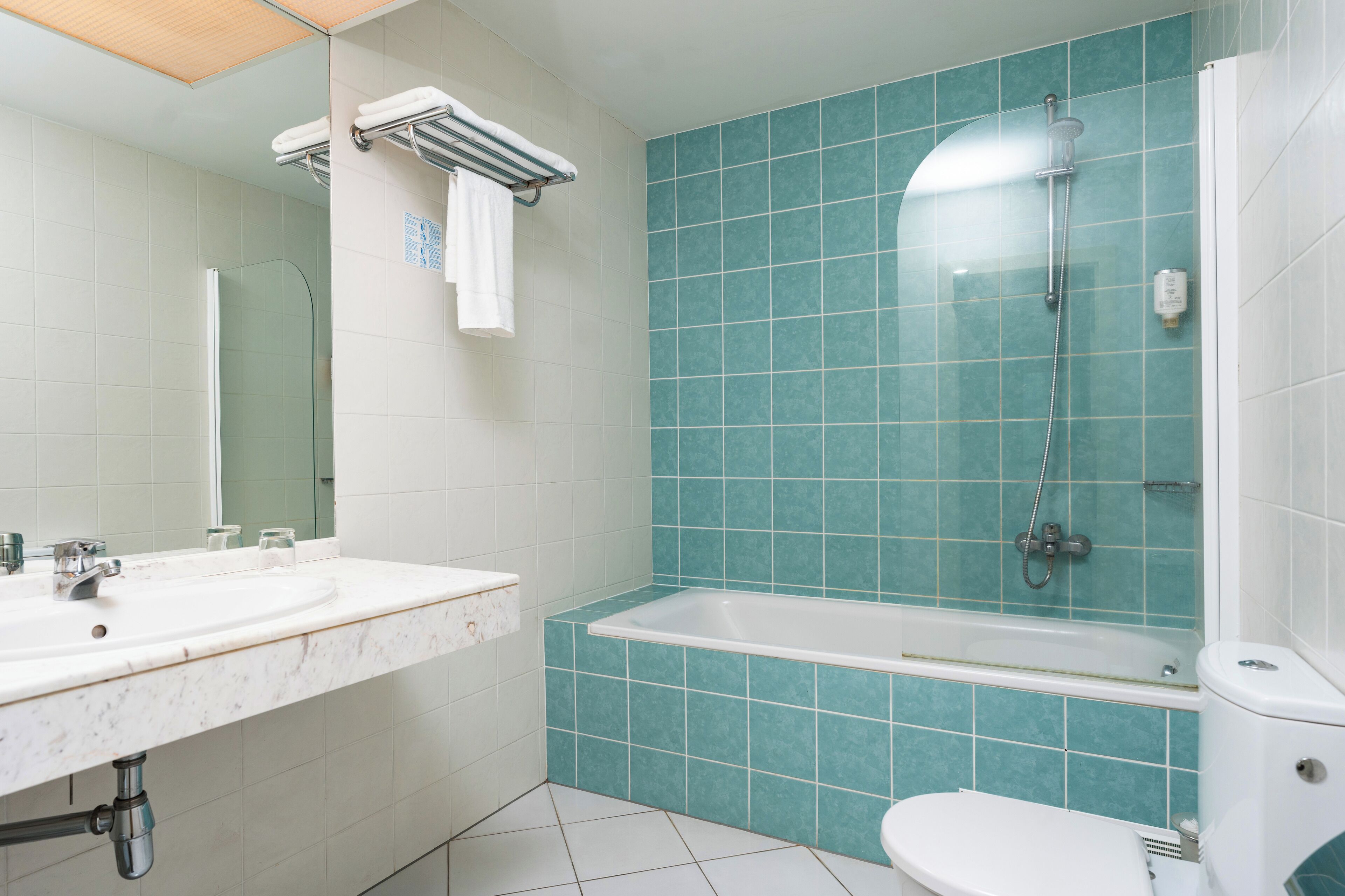 A bathroom with a white sink, a bathtub, and a toilet.