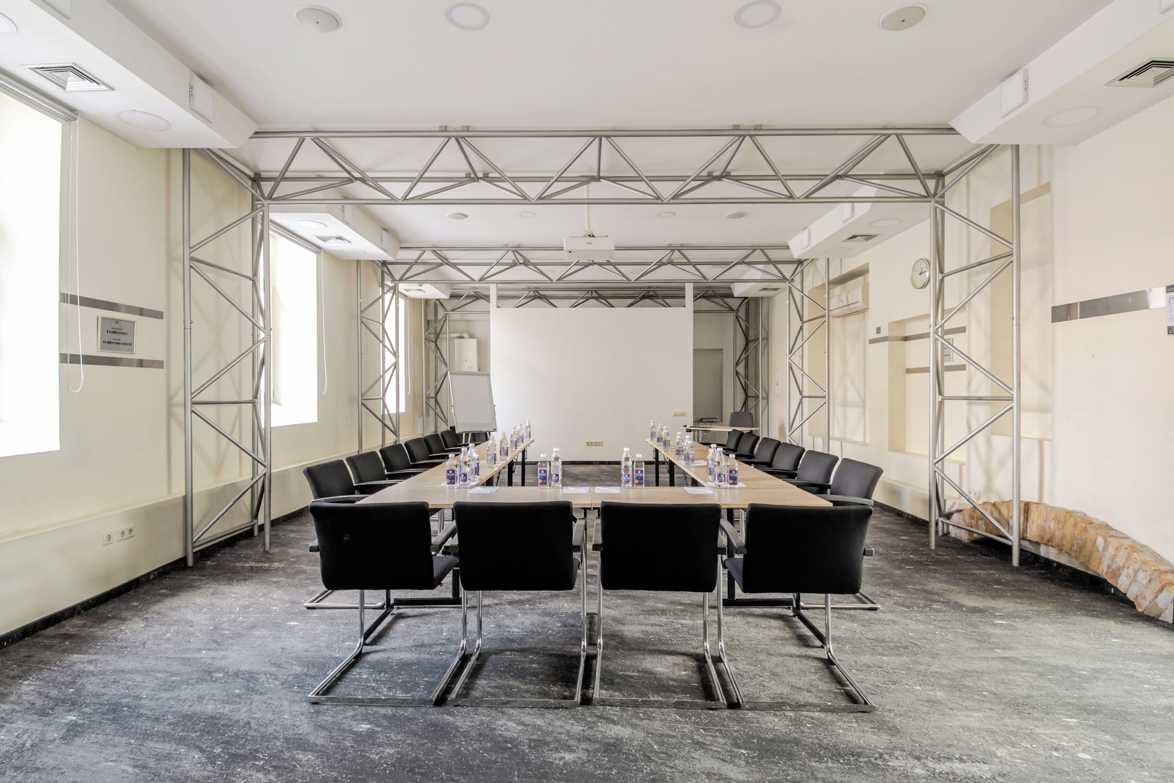 A conference room with a long table, chairs, and water bottles.