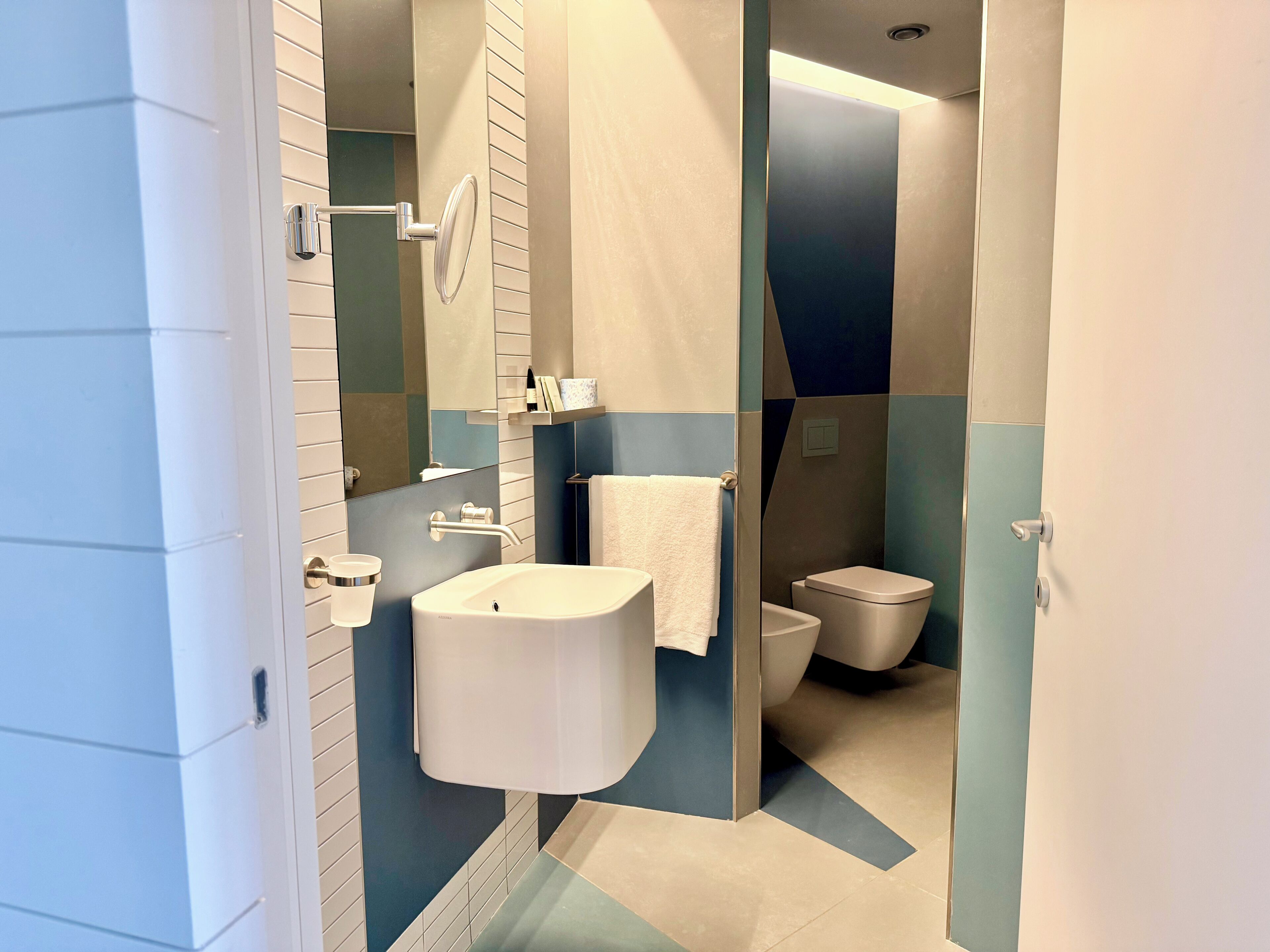 A modern bathroom with a sink, toilet, and shower area.