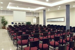 A conference room with rows of chairs, a projector screen, and a whiteboard. - Duca D'aosta (Mogliano Veneto)