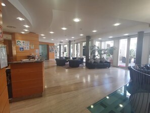 A spacious lobby with a reception desk, seating areas, and large windows allowing natural light. - Duca D'aosta (Mogliano Veneto)