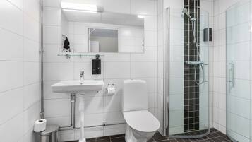 Une salle de bain moderne avec une douche à parois de verre, un lavabo blanc et des toilettes.