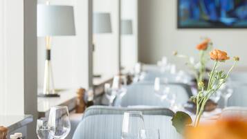 A dining area with tables set for a meal, including wine glasses and cutlery.