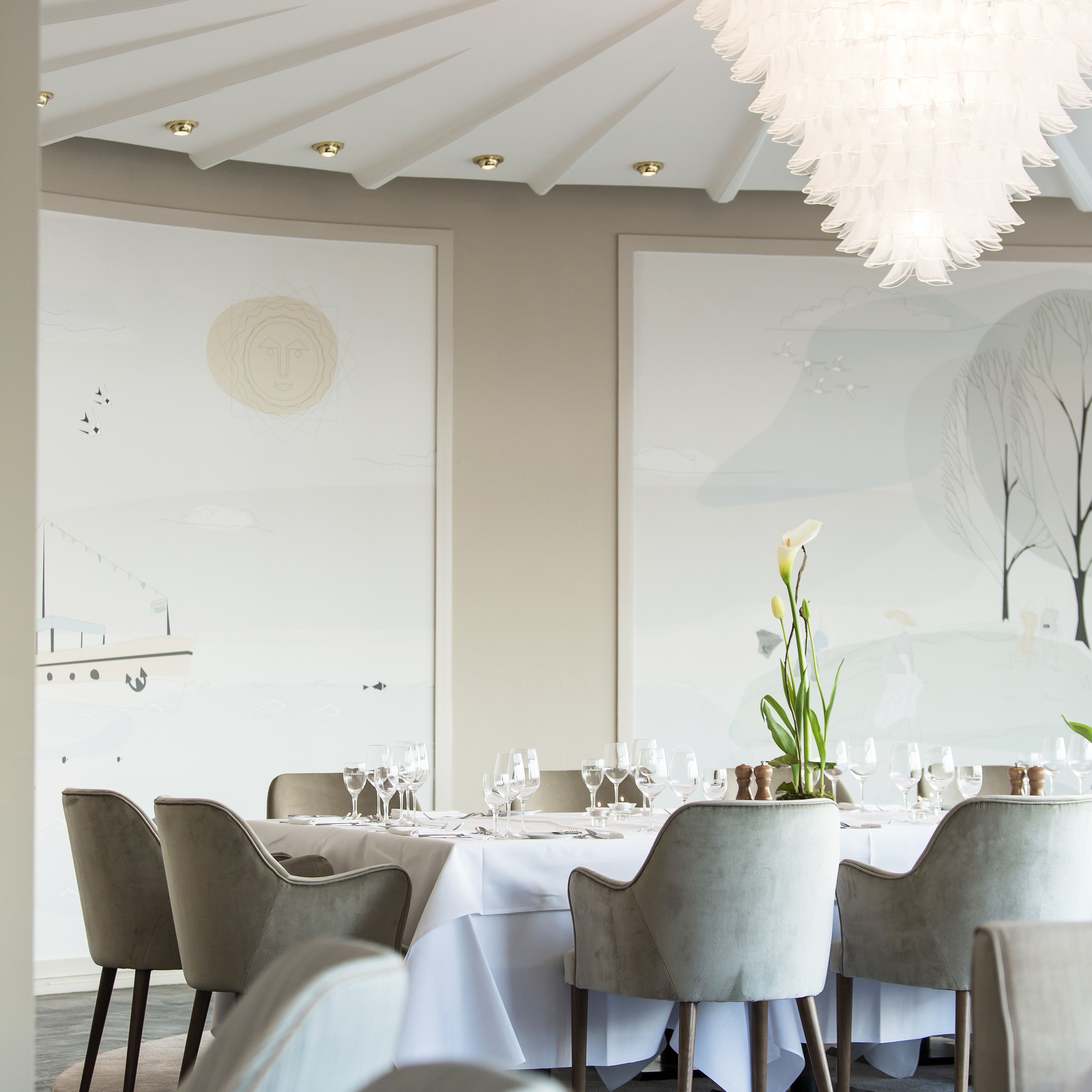 Comedor con una mesa dispuesta para seis personas, seis sillas y una araña.