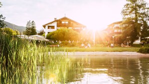 Vistes al llac amb un edifici que té balcons i una zona de jardí.