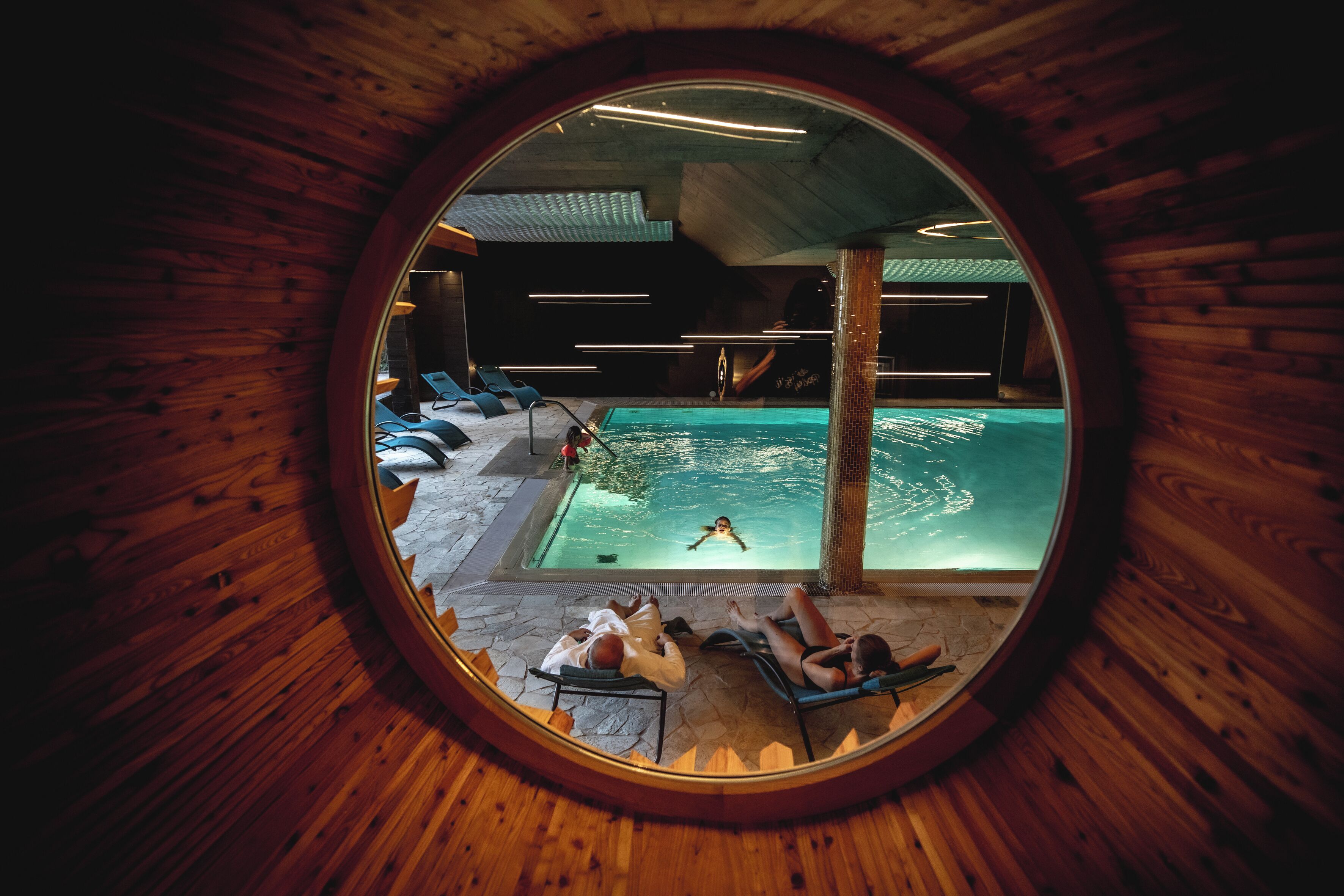 Una piscina cubierta, sombrillas, tumbonas