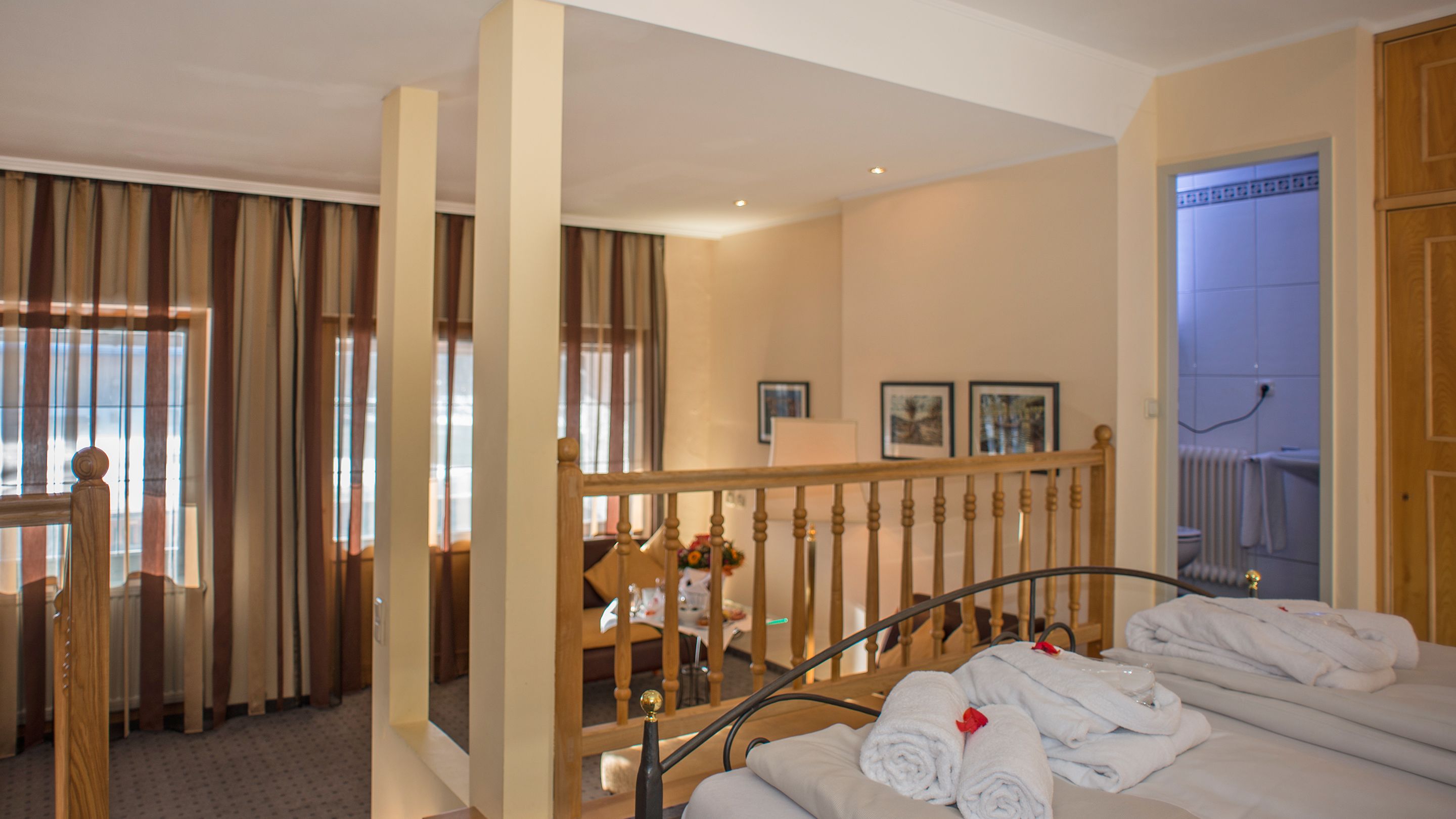 Una habitación de hotel con cama, baño y escalera.