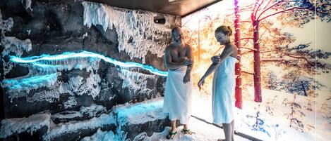 Una habitación con pared de roca, formaciones de hielo y un mural de un paisaje nevado.