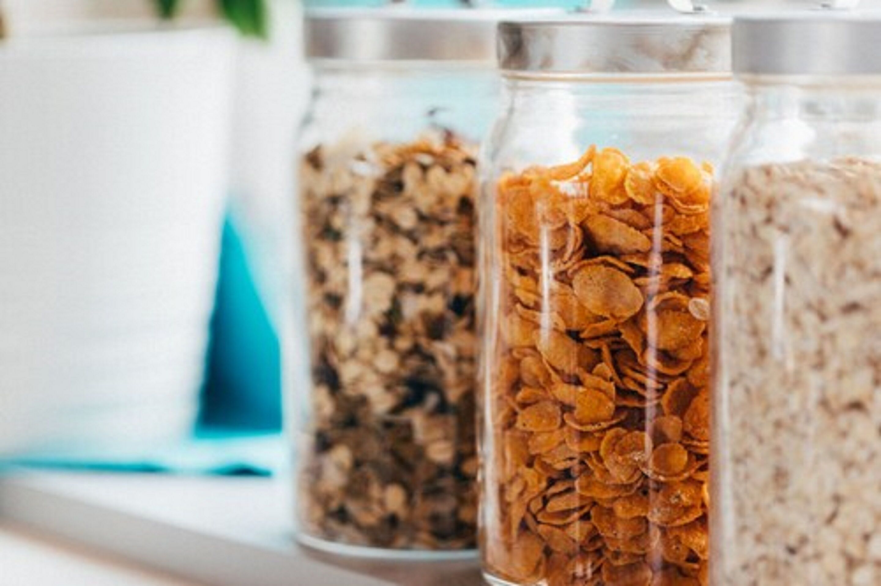 Three glass jars filled with different types of cereal.