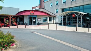 A modern building with a red awning and a sign that reads "Tegaille Grill Court."