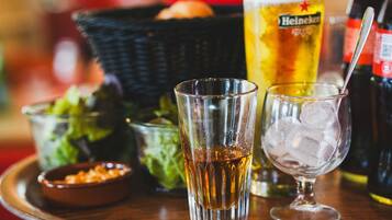 A tray with a glass of beer, a glass with ice, a bowl of salad, and a bottle of Heineken beer.