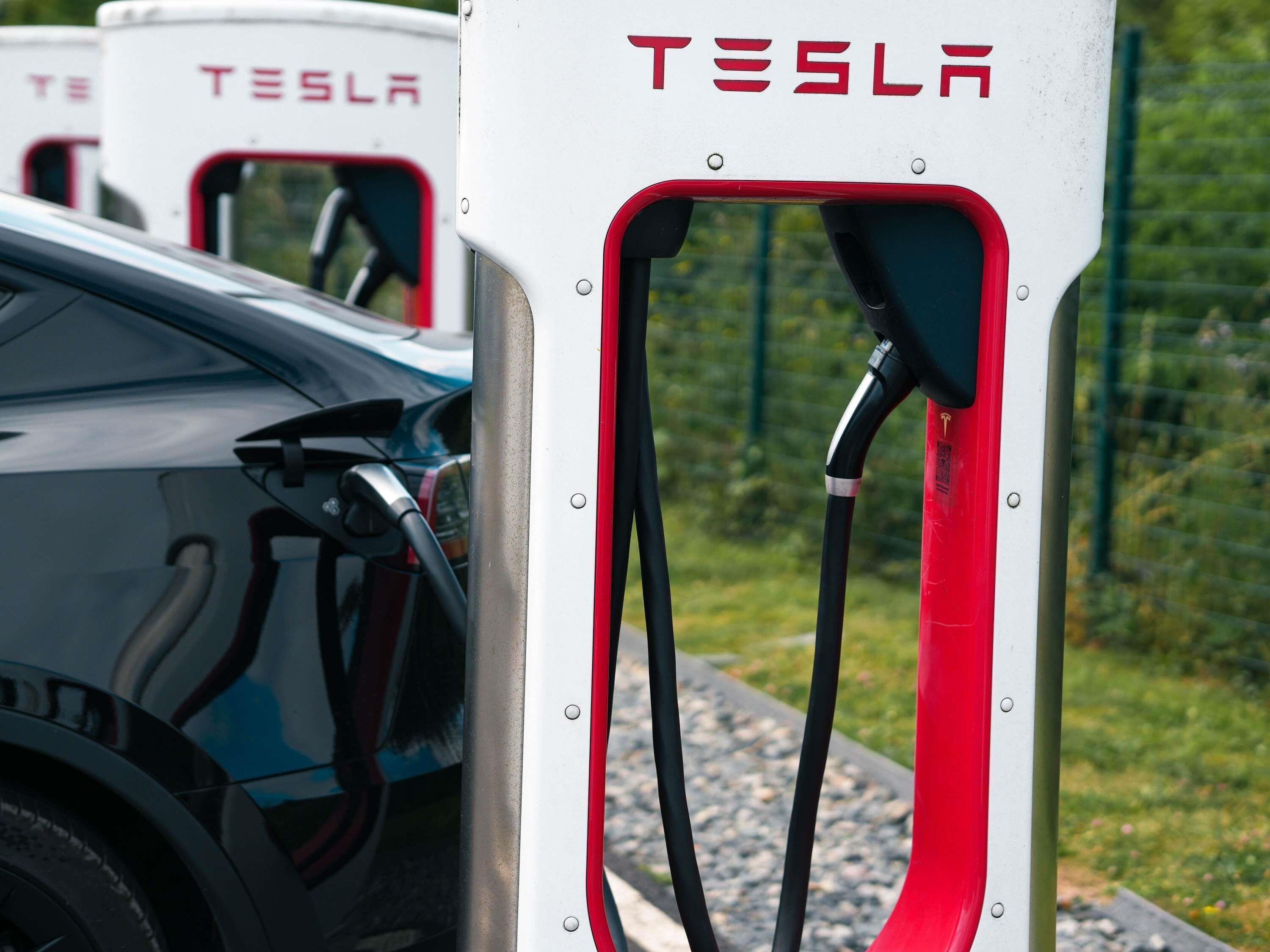 Una estación de carga de Tesla con un vehículo estacionado cerca.