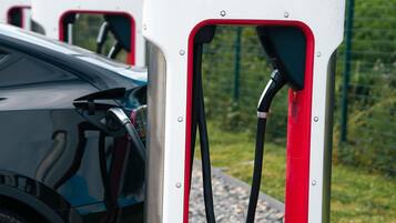 Una estación de carga de Tesla con un vehículo estacionado cerca.