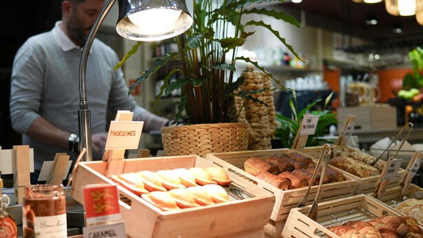 A bakery display with various baked goods and a sign indicating 'MADELEINES.'