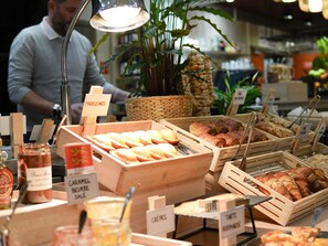 A bakery display with various baked goods and a sign indicating 'MADELEINES.'