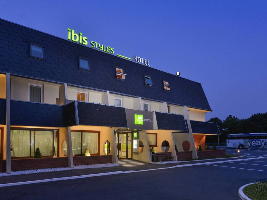 A hotel with a modern design, featuring a prominent sign for 'ibis Styles Hotel'.