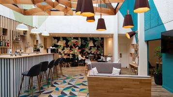 Un interior moderno con una zona de bar, asientos y un piso estampado.