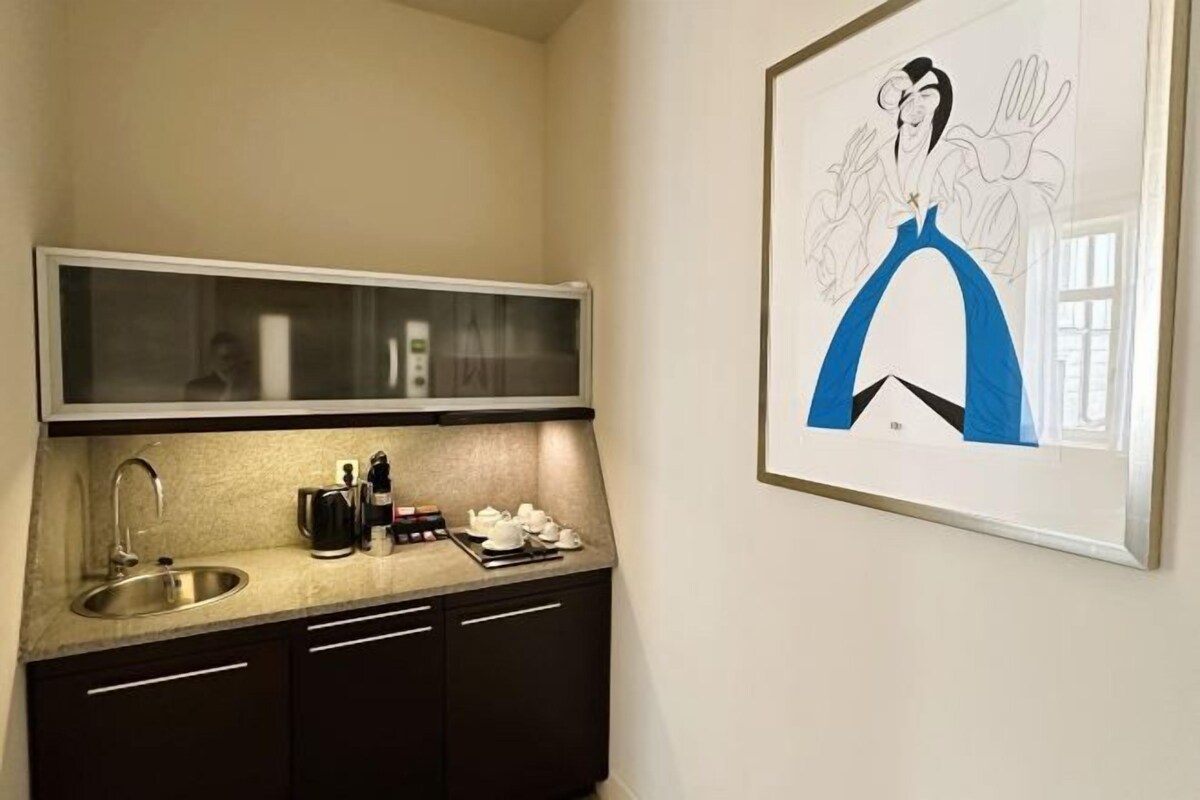 Una cocina con lavabo, cafetera y juego de té.