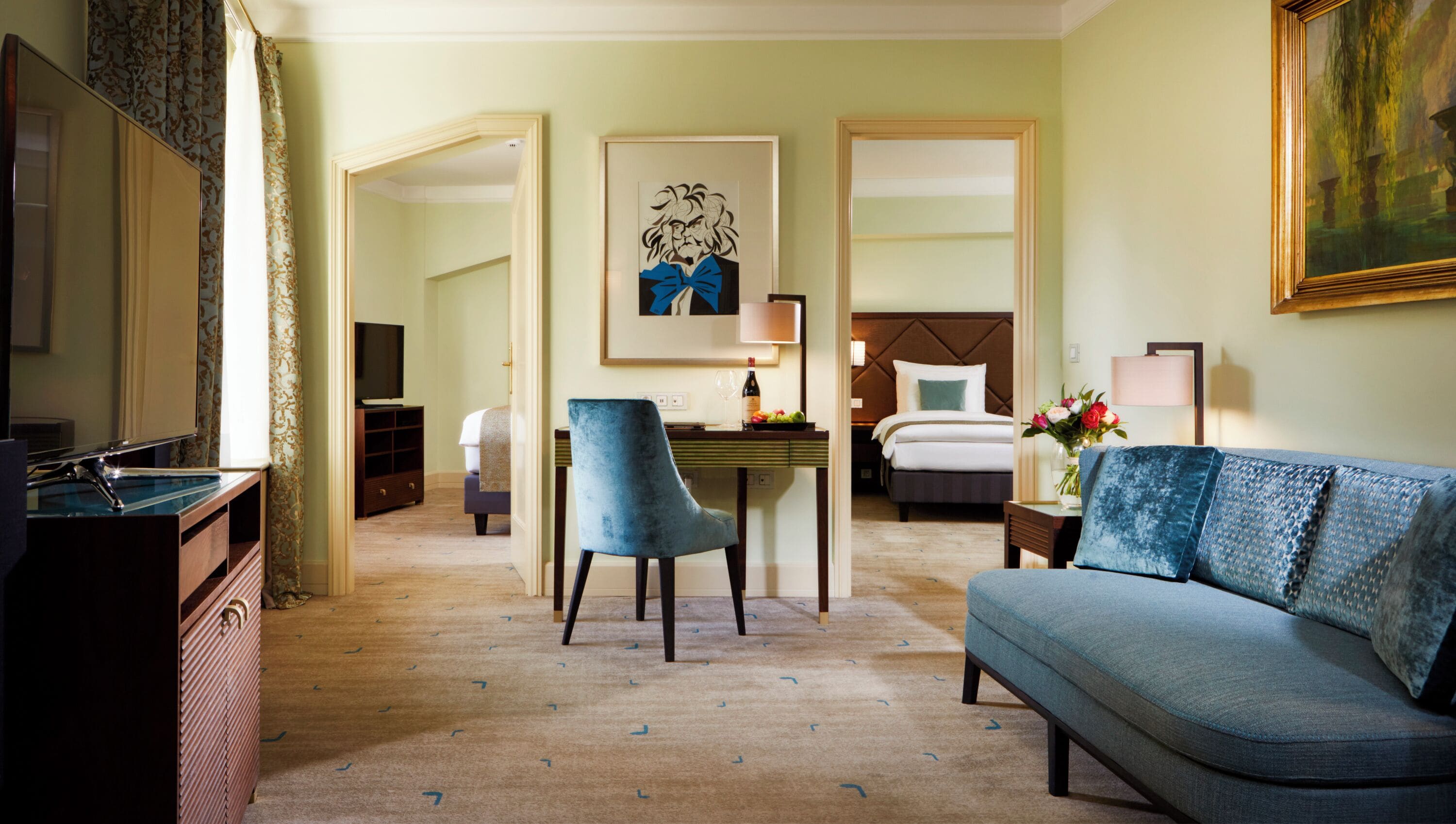 Una habitación de hotel con cama, escritorio, silla, televisión y sofá.