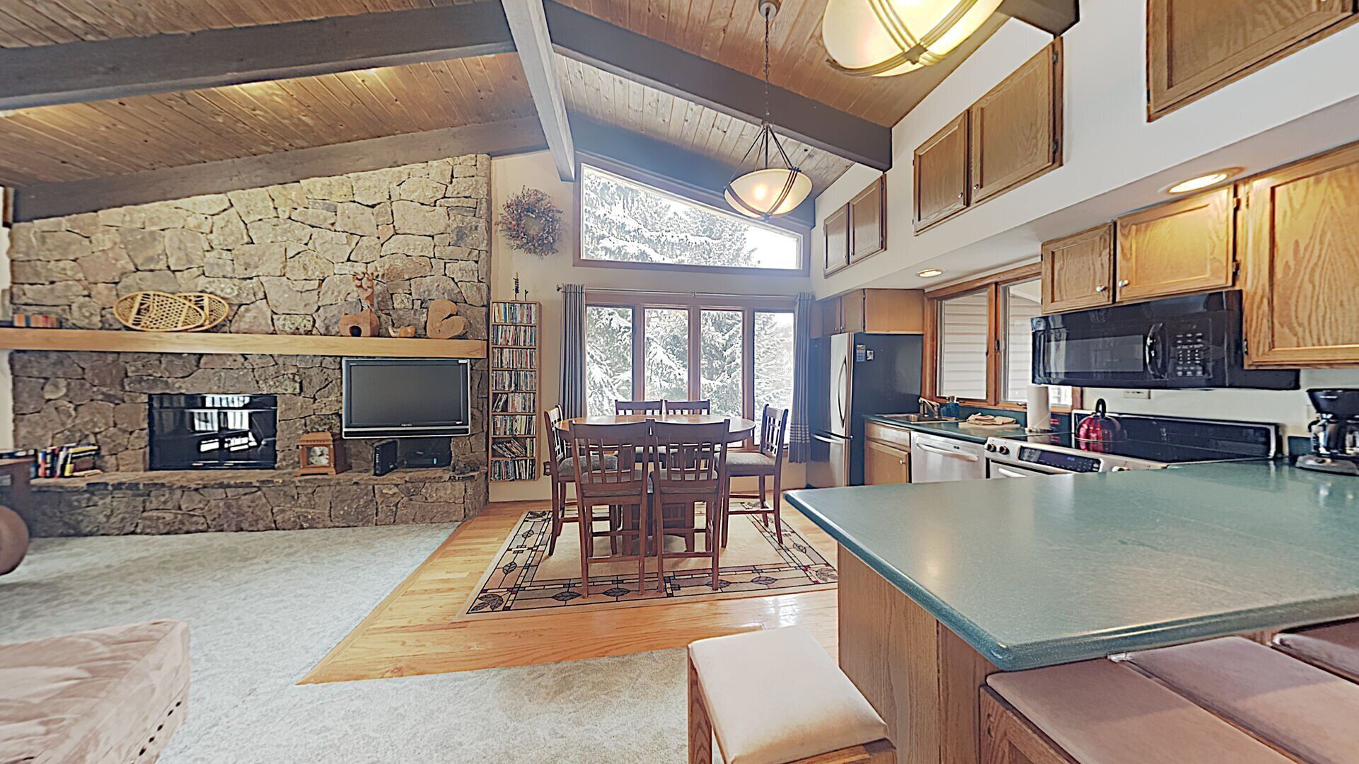 Une cuisine spacieuse avec des meubles en bois, un grand îlot central et une cheminée en pierre.