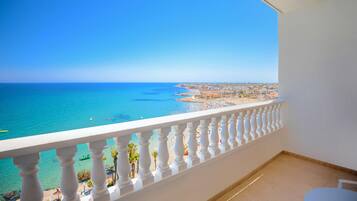 Un balcon offrant une vue dégagée sur une plage et l’océan.