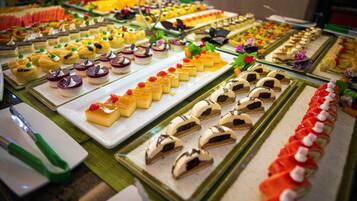 A buffet with various desserts arranged on multiple trays.