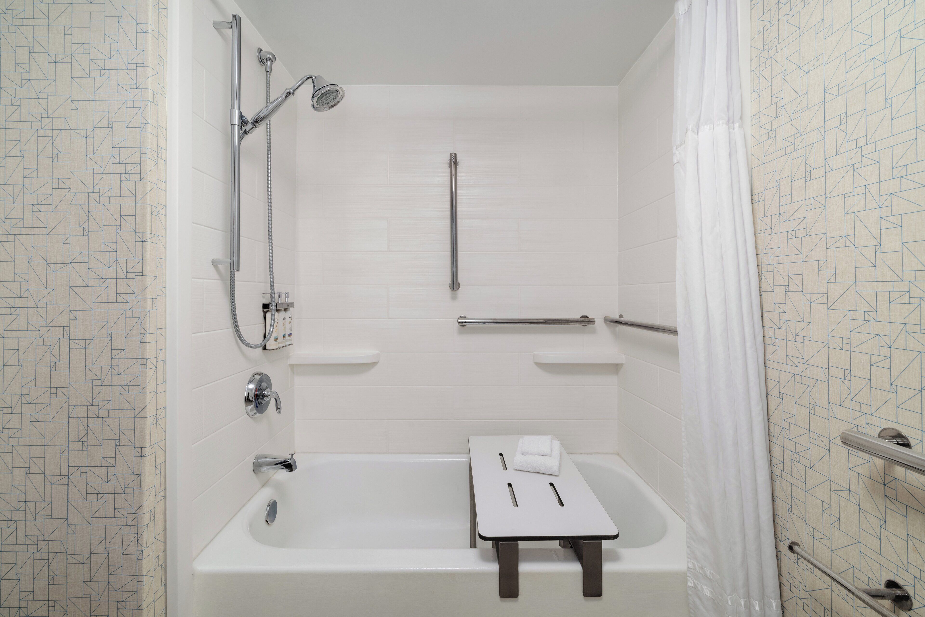A bathroom with a bathtub, a shower, a towel rack, and a toilet.