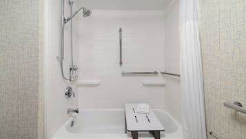 A bathroom with a bathtub, a shower, a towel rack, and a toilet.