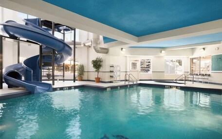 A swimming pool with a blue slide and a water feature.