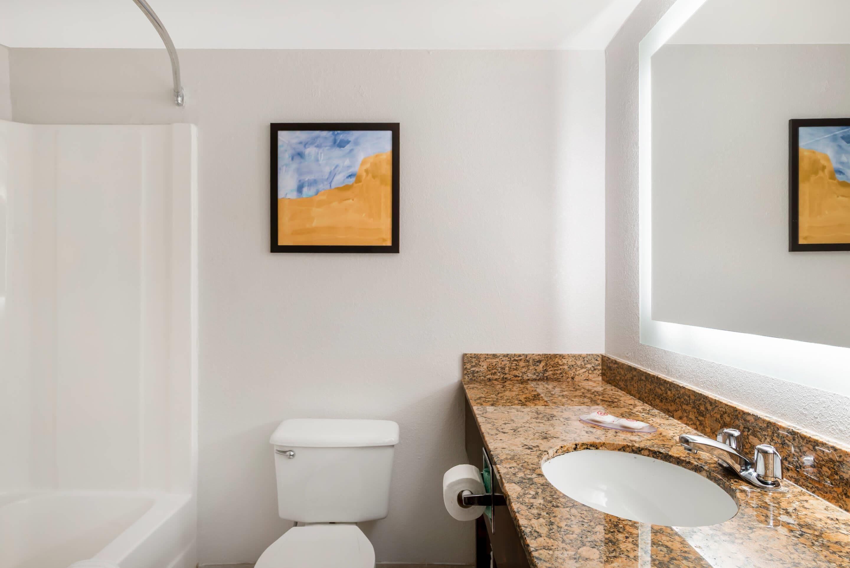 A bathroom with a toilet, sink, and shower.