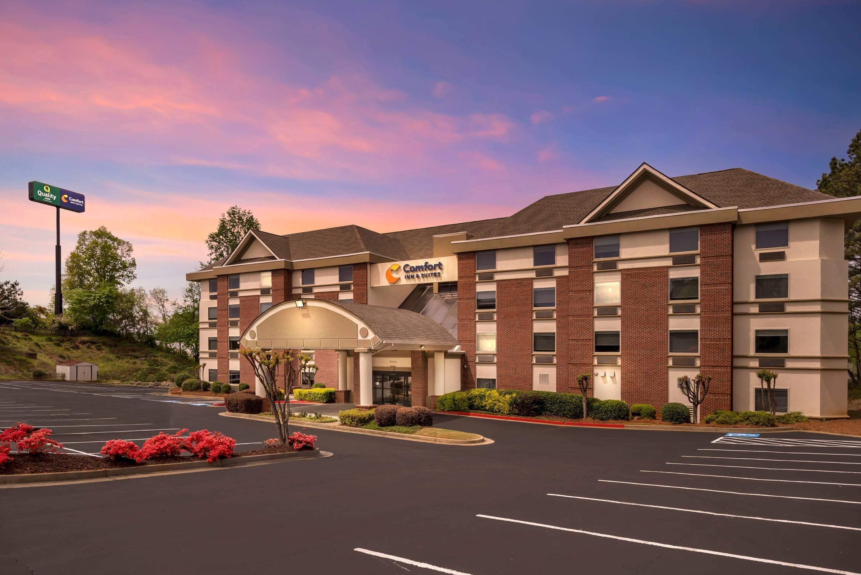 A Comfort Inn & Suites hotel with a brick facade, a parking lot, and a landscaped entrance.