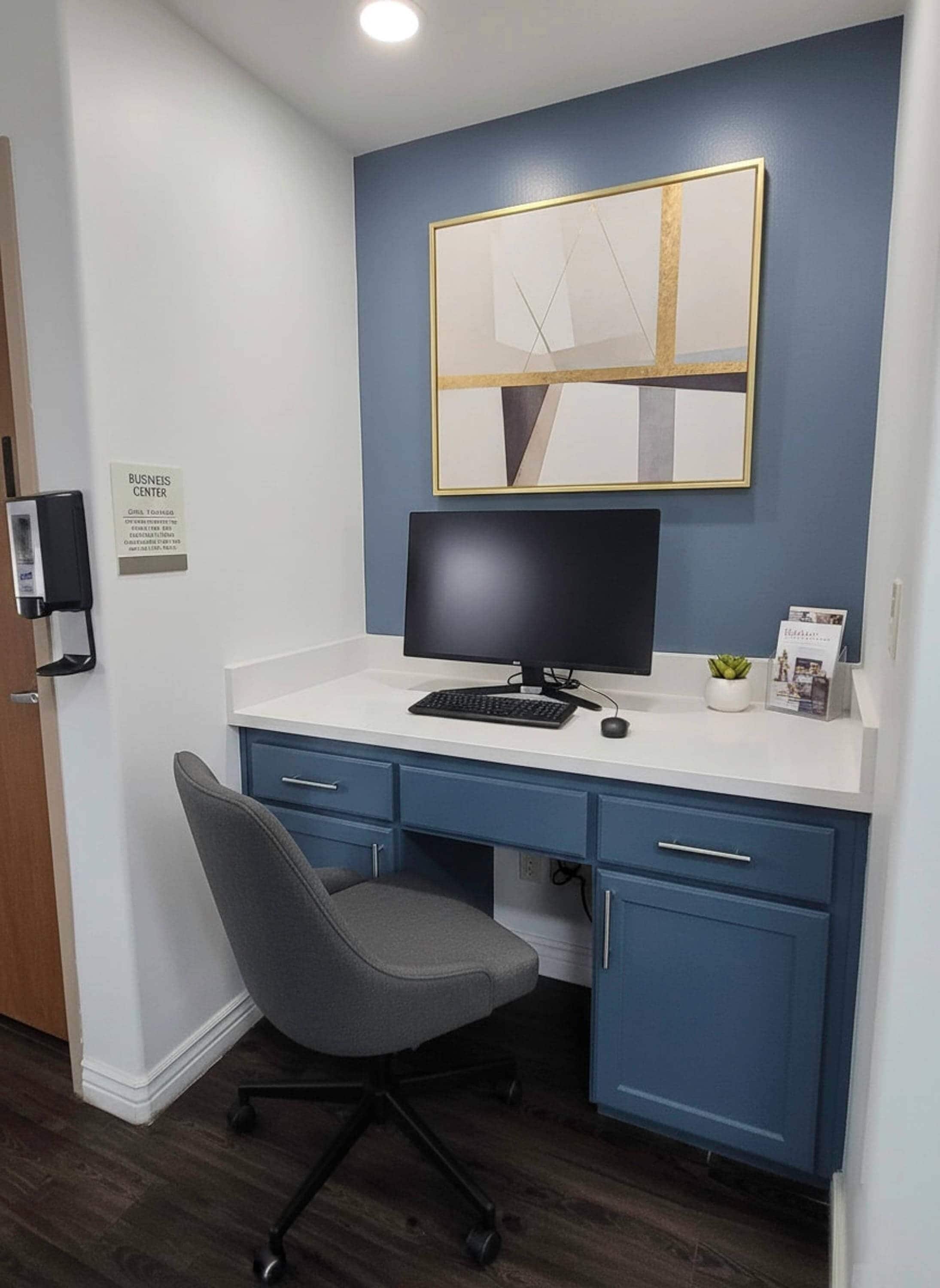 A modern office space with a desk, chair, and a computer monitor.
