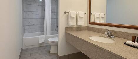 Et moderne badeværelse med bruser, toilet og håndvask.