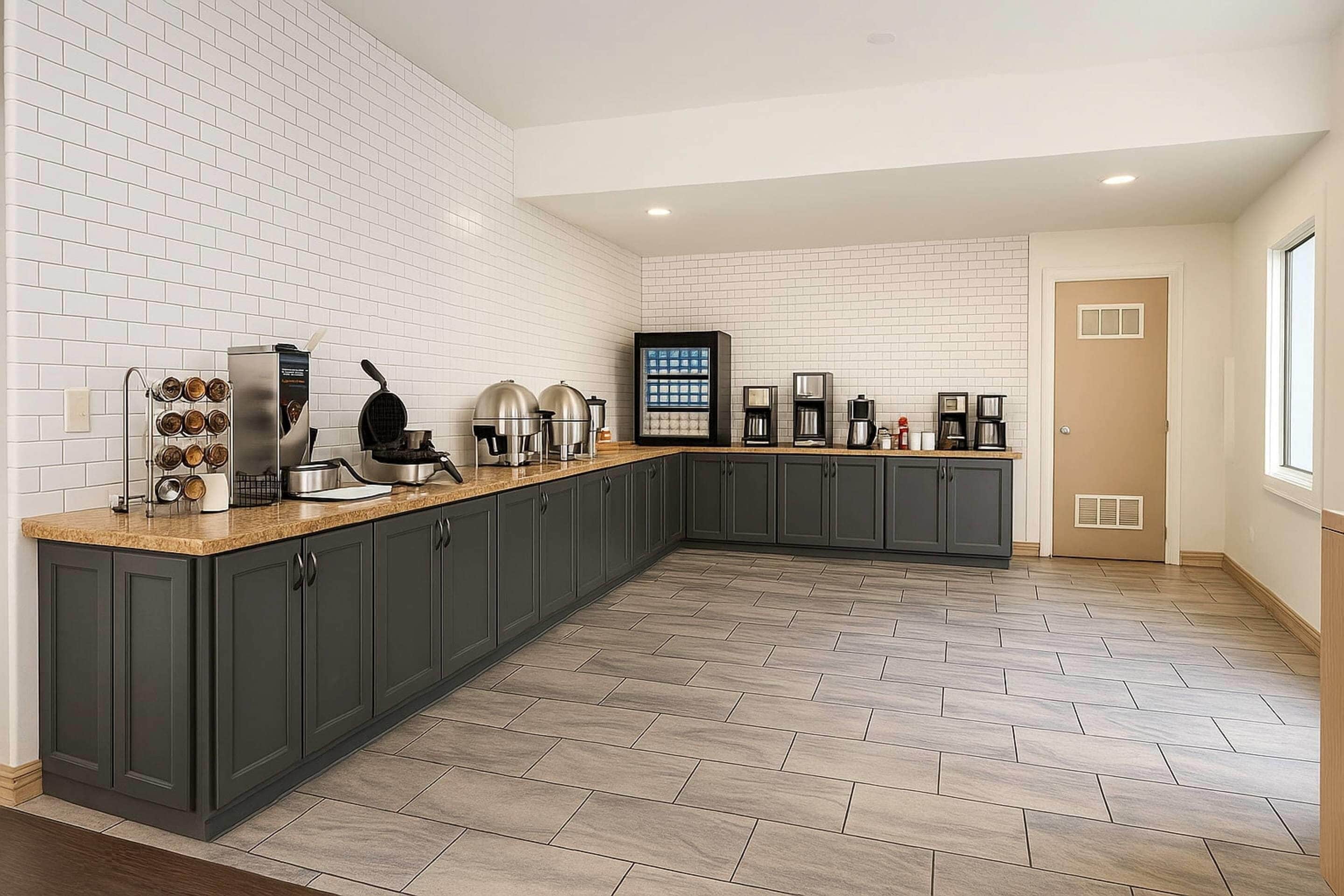 Una cocina moderna con armarios grises oscuros, encimera de madera y salpicadero de azulejos.