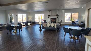 A spacious room with a fireplace, multiple seating areas, and large windows.