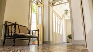 A bench in a hallway with patterned floor tiles and a potted plant. - Windsor Florida Hotel (Rio de Janeiro)