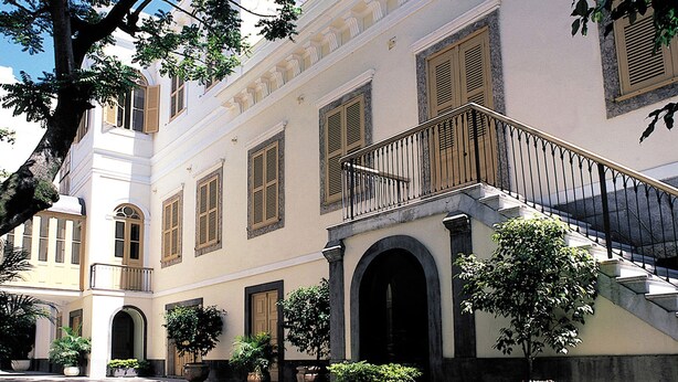 A historic building with a central courtyard, arched doorways, and a staircase leading to an upper level. - Windsor Florida Hotel (Rio de Janeiro)