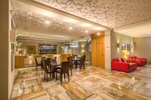 A hotel lobby with a bar area, seating, and a red sofa set.